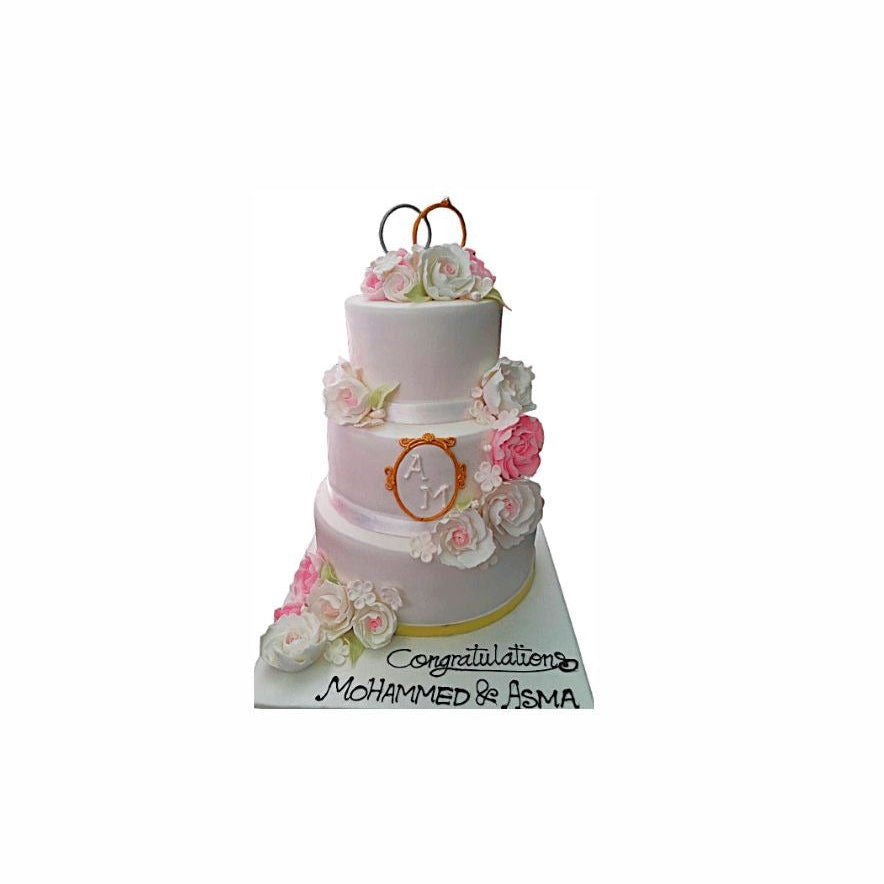 Three-Tier Wedding Cake with Pink & White Flowers and Gold Ring Topper – Elegant Engagement Cake | Abu Dhabi & UAE Delivery in Abu Dhabi | Wedding / Engagement Cakes Delivery UAE – Legrandeuae