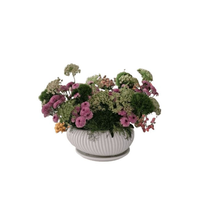 Pink and green floral arrangement in a white decorative ceramic bowl - Abu Dhabi